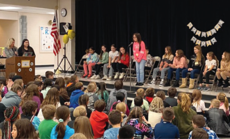 Tia Geiser, 4th-grade student, competing at a school spelling bee in front of an audience.