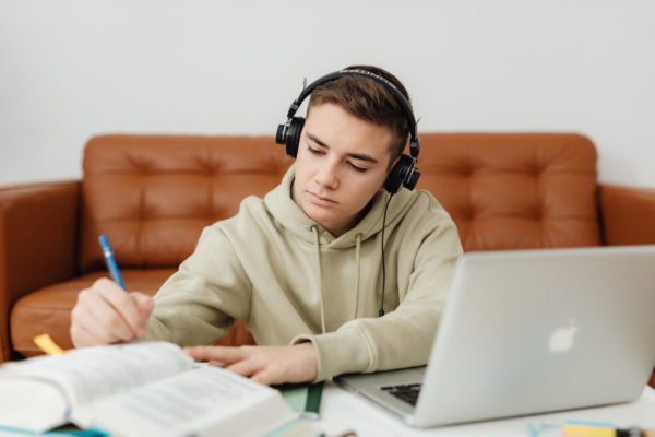Photo of a Boy Doing His Homework while Listening to Music taken by Karolina Grabowska. Found through Pexels.
