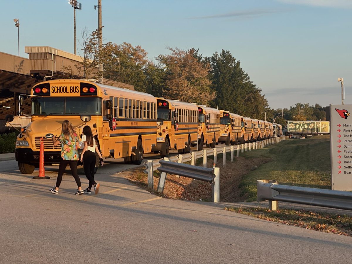 Team buses from Medina High School lined up next to the football field.