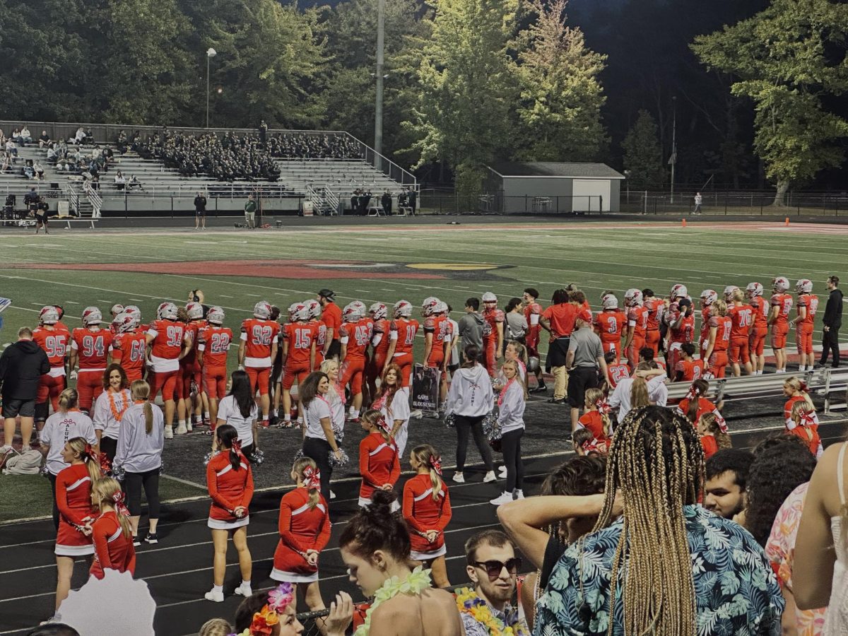 Mentor cheerleaders and footballers on the sideline.