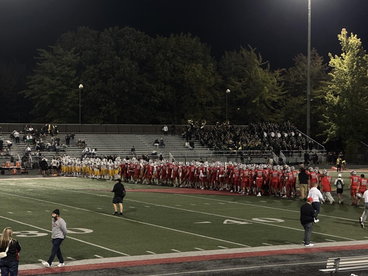 Mentor and Medina players meet at midfield to shake hands after the game.