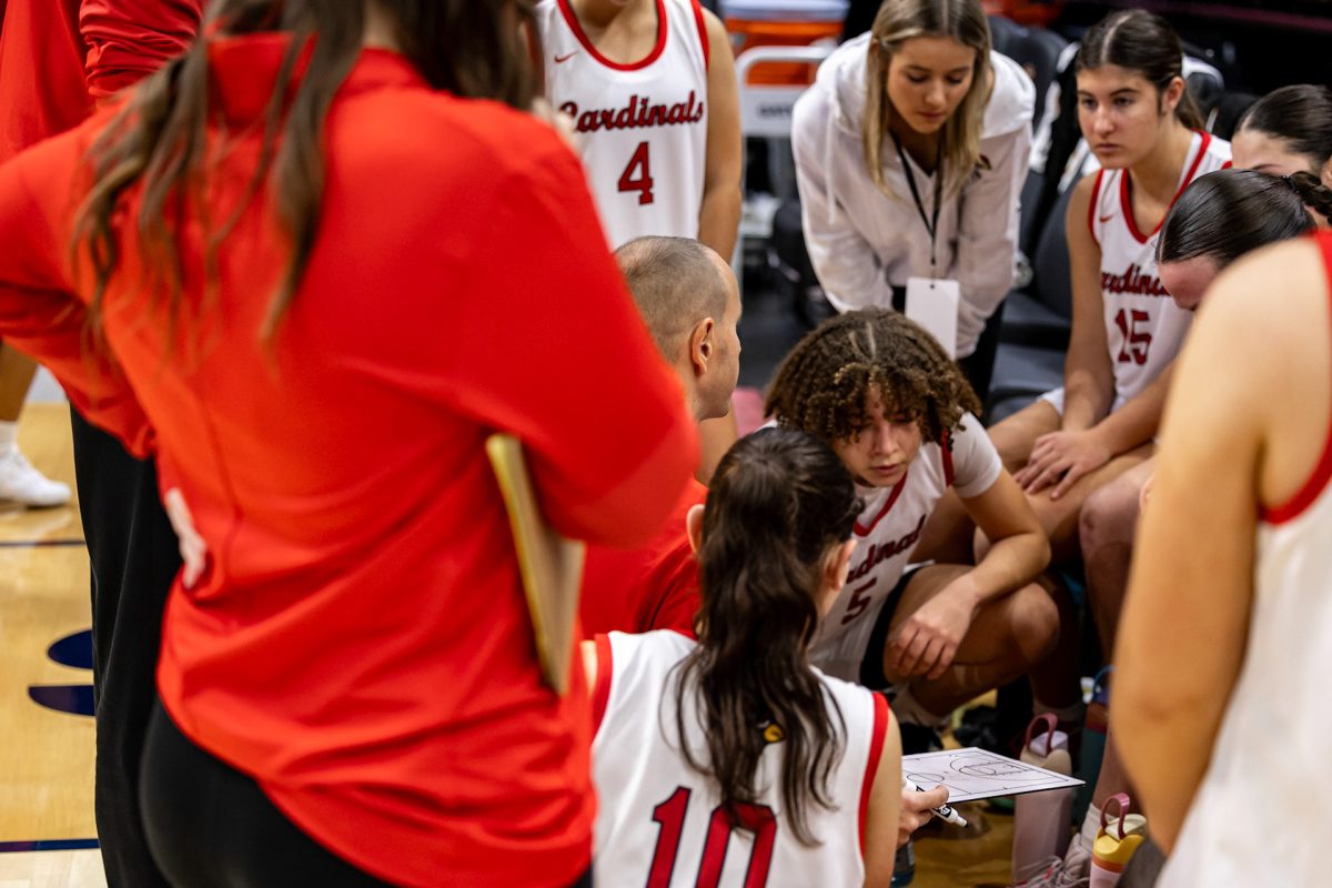 The Mentor Cardinals Girls Basketball Team in a team huddle